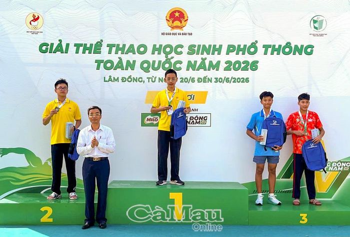 Em Đặng Đình Nguyên (bên trái) nhận Huy chương Đồng môn bơi.