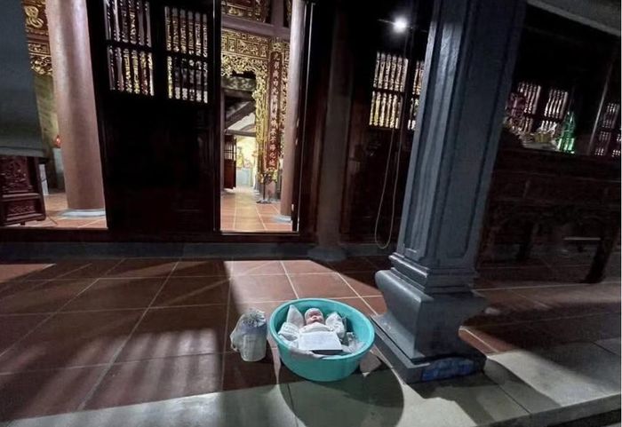 Cháu bé được bỏ trong chậu nhựa để trước cửa chùa. Ảnh: TP.