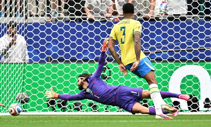 Thủ môn Alisson Becker vươn tay hết cỡ vẫn không chạm đến bóng. (Ảnh: Reuters)