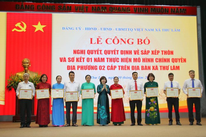 Bí thư Đảng ủy, Chủ tịch HĐND xã Thư Lâm Nguyễn Thị Thanh Tâm trao quyết định khen thưởng các tập thể, cá nhân có thành tích xuất sắc. Ảnh: Cao Kỳ