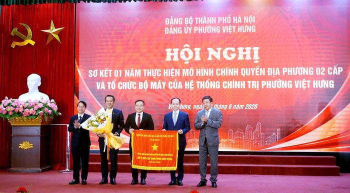 Phó Chủ tịch Thường trực UBND thành phố Hà Nội Dương Đức Tuấn trao Cờ thi đua của Thủ tướng Chính phủ tặng Đảng ủy, chính quyền nhân dân phường Việt Hưng. Ảnh: B.Duy