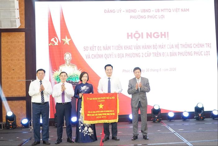 Đồng chí Dương Đức Tuấn, Phó Chủ tịch Thường trực UBND thành phố Hà Nội trao tặng cờ thi đua đơn vị xuất sắc của thành phố tới phường Phúc Lợi. Ảnh: Nguyễn Bình