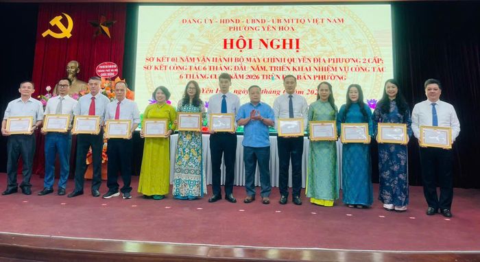 Đồng chí Nguyễn Xuân Hậu, Trưởng phòng Khoa giáo, Ban Tuyên giáo và Dân vận Thành ủy Hà Nội trao thưởng cho các tập thể tại hội nghị sơ kết 1 năm vận hành mô hình chính quyền địa phương hai cấp trên địa bàn phường Yên Hòa. Ảnh: PV