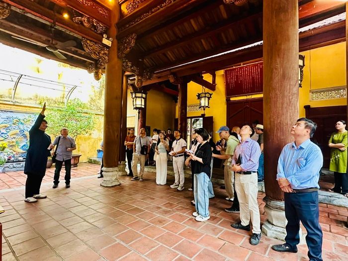 Du khách tìm hiểu kiến trúc độc đáo và các câu chuyện văn hóa tại đền Bạch Mã. Ảnh: Hoàng Quyên