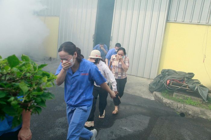 Các cán bộ, công nhân thực tập phương án thoát nạn khi có cháy. Ảnh: HN