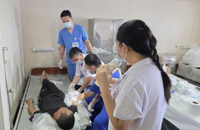 Hình ảnh kíp can thiệp tỉ mẩn, bó bột cho người dân bị tai nạn lao động dưới ánh đèn rọi của Tiến sĩ Hà Lan Phương (Viện Sức khỏe Nghề nghiệp và Môi trường) trên tàu 561 khiến ai nấy đều xúc động. Ảnh: Minh Lý