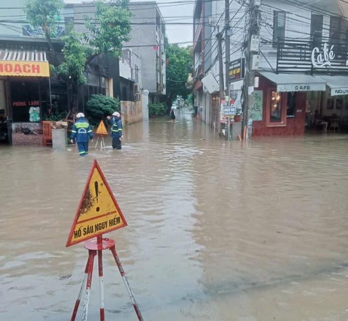 Lực lượng chức năng cắm biển cảnh báo ở những khu vực ngập sâu để người dân chú ý khi lưu thông - Ảnh: H. Khôi