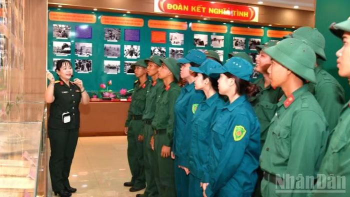 Cán bộ, chiến sĩ lực lượng vũ trang Quân khu nghe thuyết minh về hình ảnh lịch sử.