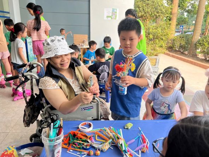 Chị Nguyễn Thị Cẩm Nhung hướng dẫn và dạy trẻ em cách làm hoa từ các vật liệu tái chế. 