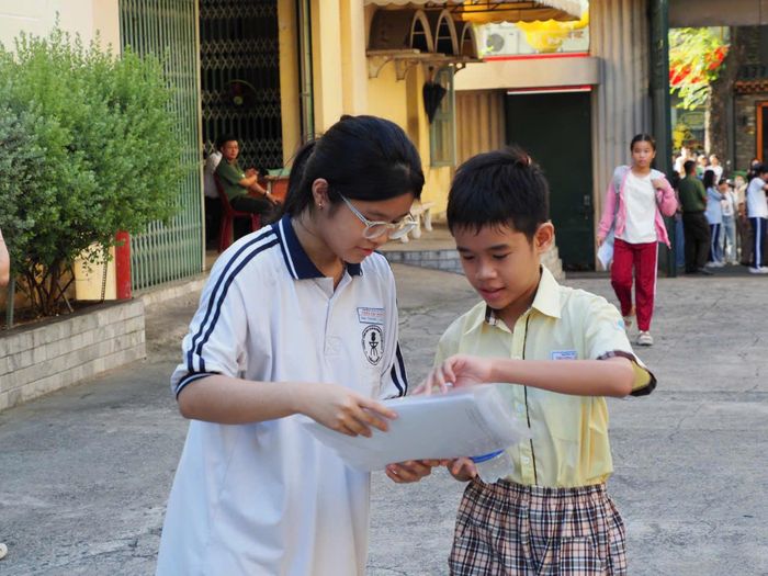  Điểm thi THCS-THPT Trần Đại Nghĩa bố trí tình nguyện viên hướng dẫn thí sinh từ cổng trường. Ảnh: THU TÂM. 