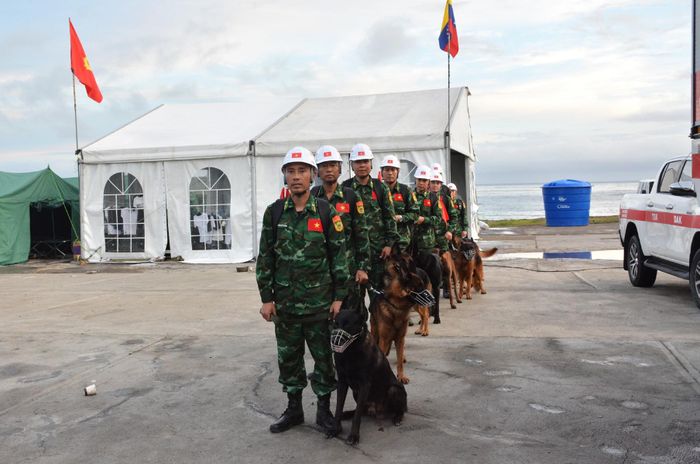 Đoàn Việt Nam và đội chó nghiệp vụ cơ động ra hiện trường làm nhiệm vụ. Ảnh: BQP
