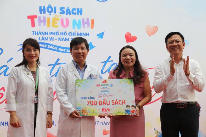 Đại diện Bệnh viện Nhi đồng 1 đón nhận bảng tượng trưng 700 đầu sách từ Ban tổ chức. Ảnh: BTC