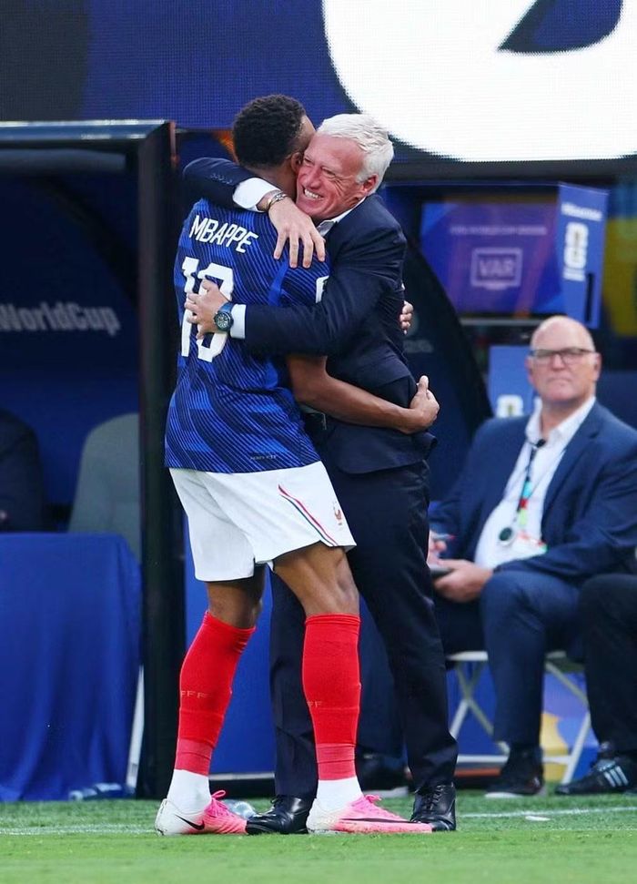 Mbappe chạy thẳng đến chỗ HLV Didier Deschamps để chia vui sau khi mở tỉ số. Ảnh: Reuters.
