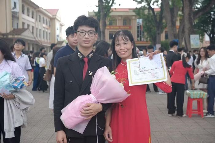 Công chụp ảnh với mẹ trong lễ tuyên dương.