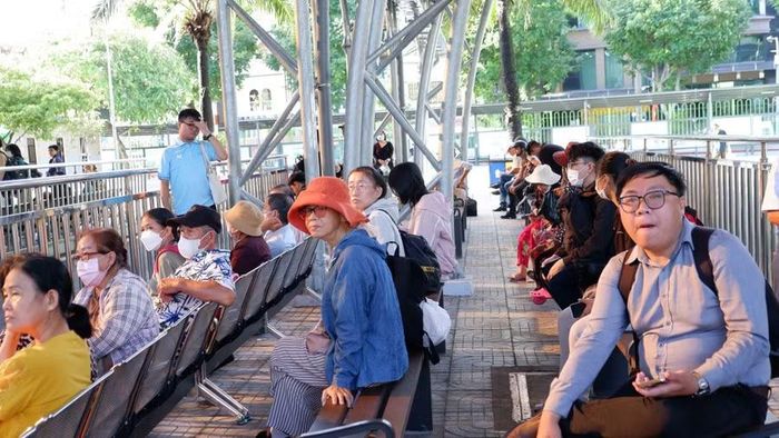 Người dân TPHCM chờ xe buýt sáng 1/7. Ảnh: Hữu Huy.