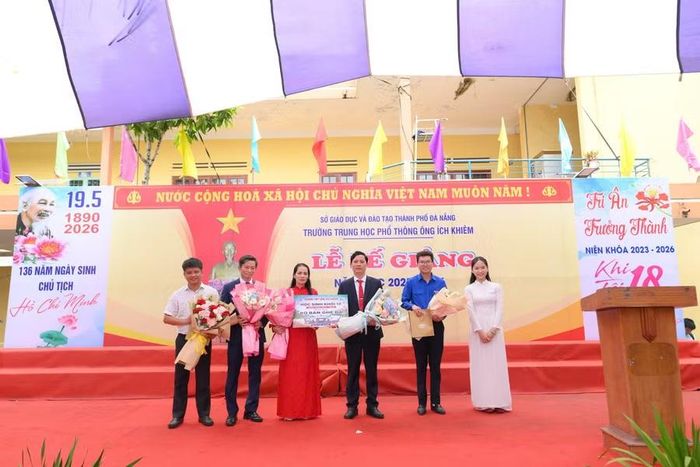 Em Huỳnh Thị Ngọc Phương (áo dài trắng) đại diện học sinh khối lớp 12 tặng hoa tri ân thầy cô trong Lễ bế giảng.