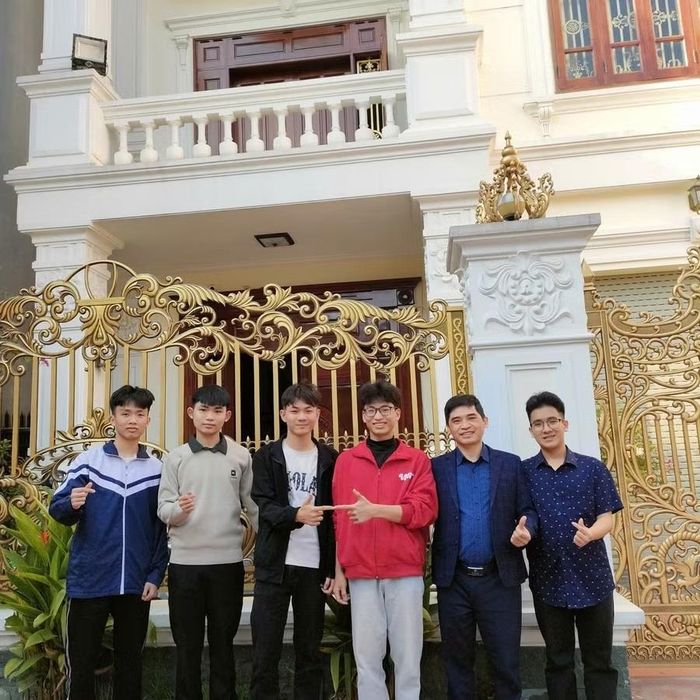 Công (áo đỏ) chụp ảnh cùng thầy giáo và các bạn. Ảnh: NVCC