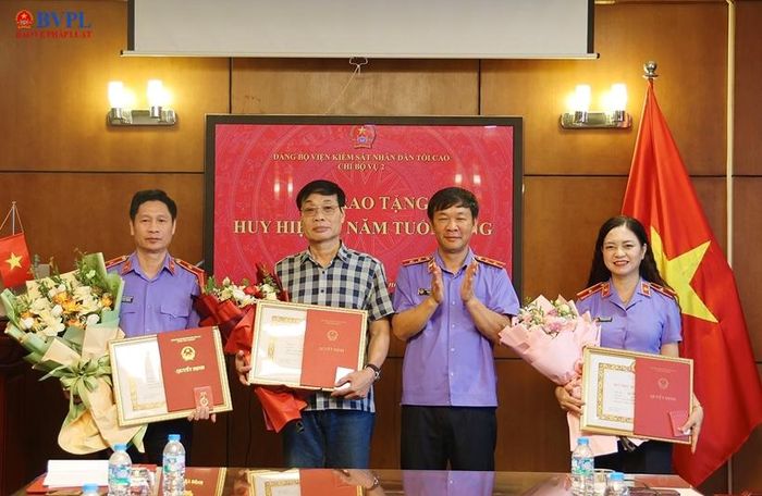  Đồng chí Lê Minh Long, Ủy viên Ban Chấp hành Đảng bộ VKSND tối cao, Bí thư Chi bộ, Vụ trưởng Vụ 2 trao tặng Huy hiệu 30 năm tuổi Đảng và tặng hoa chúc mừng 3 đồng chí.