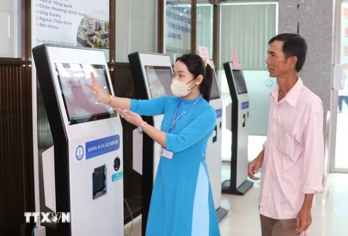 Người bệnh được hướng dẫn đăng ký khám, lấy số thứ tự qua ki-ốt tự động của Bệnh viện Đa khoa Tiền Giang. (Ảnh: Hữu Chí/TTXVN)