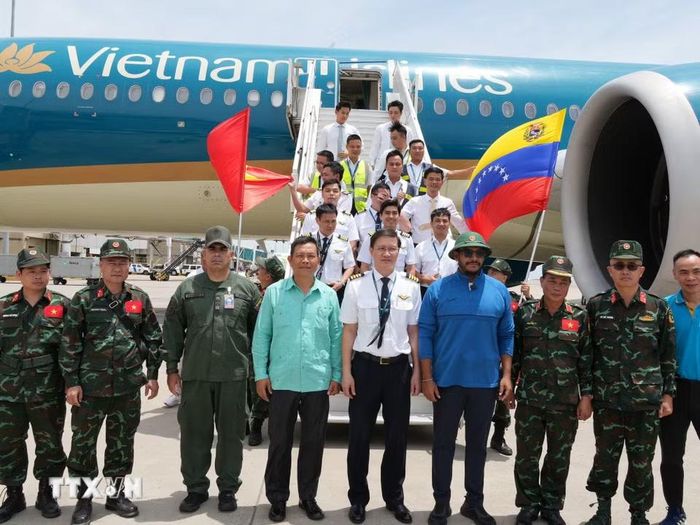 Đại diện đoàn cứu hộ Việt Nam chụp ảnh chung với đại diện lãnh đạo Venezuela và tổ bay Vietnam Airlines. (Ảnh: Phi Hùng/TTXVN)