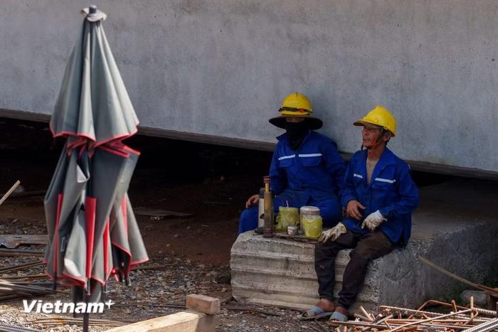 Phút nghỉ ngơi hiếm hoi của các công nhân. Họ tranh thủ ngả lưng, tránh nắng ngay dưới bóng râm của những bệ mố trụ cầu vừa hoàn thành. (Ảnh: Thanh Phong/Vietnam+)