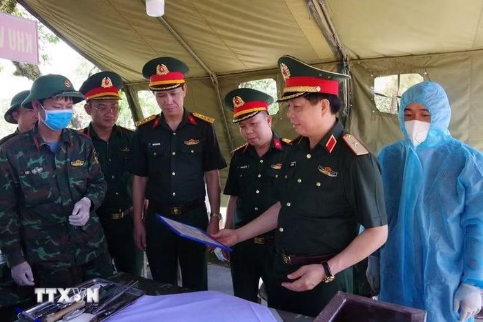 Đoàn công tác Quân khu 4 kiểm tra, thăm hỏi, động viên và tặng quà các lực lượng đang thực hiện nhiệm vụ lấy mẫu, số hóa thông tin và bàn giao mẫu hài cốt liệt sỹ tại Nghĩa trang Liệt sĩ Quốc gia Đường 9. (Ảnh: TTXVN phát)
