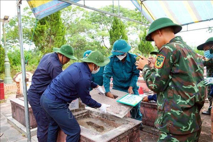 Các lực lượng tham gia khai quật, lấy mẫu AND phần mộ liệt sĩ. Ảnh: Hữu Quyết /TTXVN
