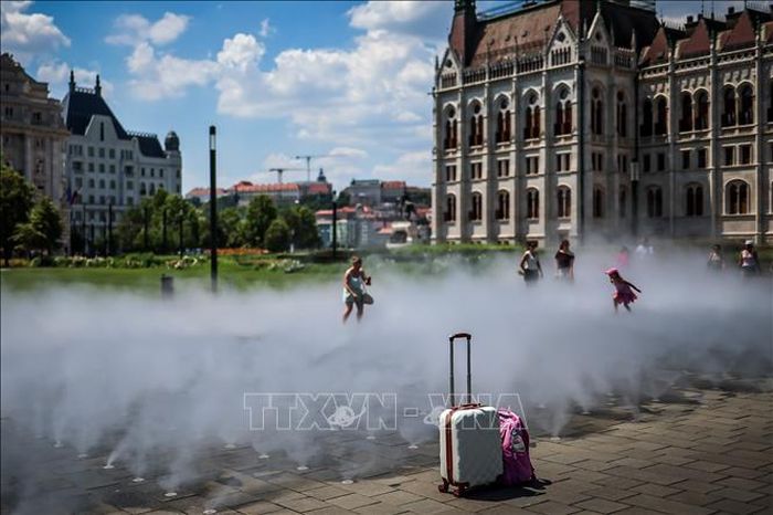 Người dân làm mát tại hệ thống phun sương ở Budapest, Hungary ngày 24/6/2026. Ảnh: THX/TTXVN phát