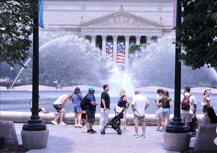 Du khách tránh nắng nóng bên đài phun nước tại khu vực National Mall (Quảng trường Quốc gia) ở thủ đô Washington D.C. Ảnh: Ngọc Quang/PV TTXVN tại Mỹ