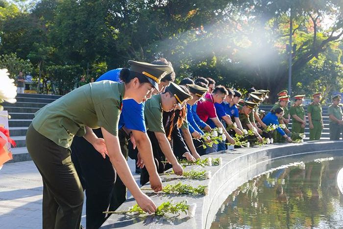 Đại biểu và đoàn viên thanh niên thực hiện nghi thức dâng hoa tại Tượng đài Giọt nước, Công viên số 1 Lý Thái Tổ.