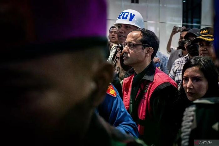 Cựu Bộ trưởng Bộ Giáo dục, Văn hóa, Nghiên cứu và Công nghệ (2019–2024) Nadiem Makarim (ở giữa) mặc áo khoác tạm giam khi ông bước ra sau khi bị thẩm vấn tại văn phòng Phó Tổng Chưởng lý phụ trách Tội phạm Đặc biệt, Văn phòng Tổng Chưởng lý, Jakarta, ngày 4/9/2025. Ảnh: Antara News.