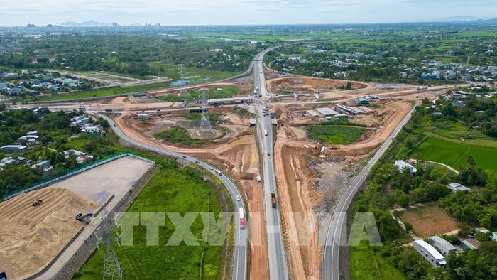 Nhìn từ trên cao, các hạng mục cầu vượt, đường dẫn và nền đường tại nút giao Quốc lộ 14B với cao tốc Đà Nẵng - Quảng Ngãi dần hiện rõ hình hài sau nhiều tháng thi công. Ảnh: Xuân Quý - TTXVN