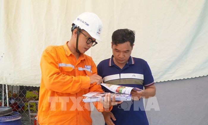 Nhân viên của Điện lực Thường Thới Tiền (Đồng Tháp) tuyên truyền, hướng dẫn người dân cách sử dụng điện an toàn. Ảnh: Nhựt An - TTXVN