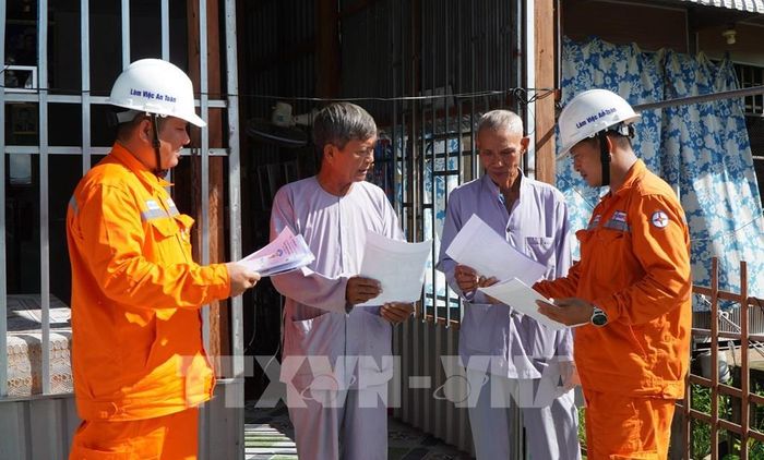 Nhân viên của Điện lực Thanh Bình (Đồng Tháp) tuyên truyền, hướng dẫn người dân cách sử dụng điện an toàn. Ảnh: Nhựt An - TTXVN