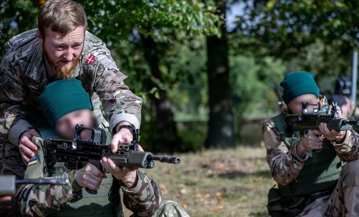 Một binh sĩ Đan Mạch hướng dẫn tân binh Ukraine cách sử dụng vũ khí cơ bản. Ảnh: Reuters.