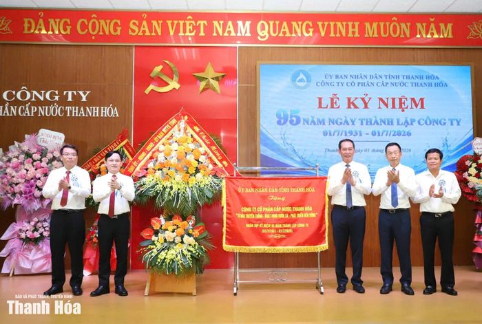 Phó Bí thư Tỉnh ủy Trịnh Tuấn Sinh và các đồng chí lãnh đạo tỉnh trao lẵng hoa của Tỉnh ủy, HĐND, UBND, Ủy ban MTTQ tỉnh và bức trướng của UBND tỉnh cho Công ty CP Cấp nước Thanh Hóa.