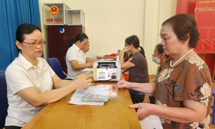 Người hưởng nhận chi trả chế độ bảo hiểm xã hội tại Hà Nội. Ảnh: T.H.