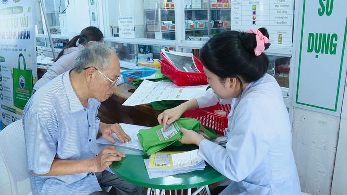 Nhân viên y tế hướng dẫn người bệnh sử dụng túi vải đựng thuốc tích hợp bộ chỉ dẫn trực quan. Ảnh: H.H