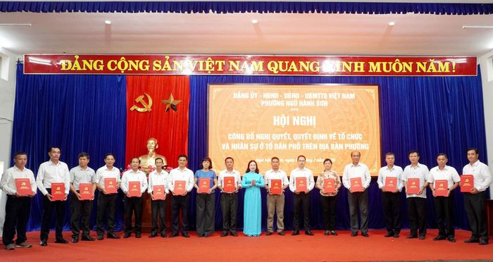 Bí thư Đảng ủy, Chủ tịch HĐND phường Ngũ Hành Sơn Mai Thị Ánh Hồng trao các quyết định nhân sự tại hội nghị. Ảnh: TRỌNG HUY