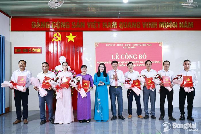 Lãnh đạo xã Tân Tiến trao quyết định, tặng hoa chúc mừng các chi bộ thôn sau sắp xếp. Ảnh: Bùi Dũng