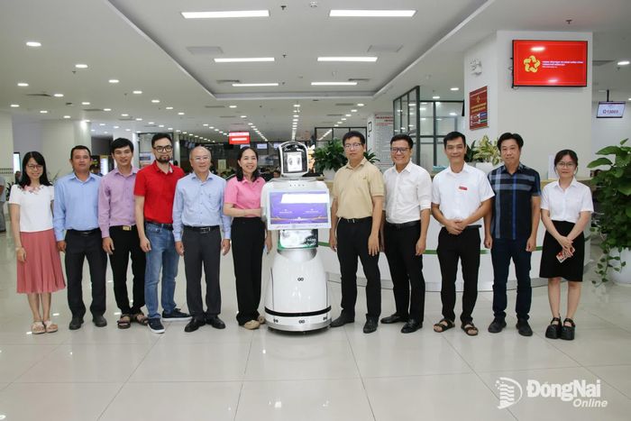 Lãnh đạo Sở Khoa học và Công nghệ, Trung tâm Phục vụ hành chính công thành phố Đồng Nai chụp ảnh cùng Robot AI do nhóm thực hiện đề tài của Trường đại học Lạc Hồng thử nghiệm. Ảnh: Hải Quân