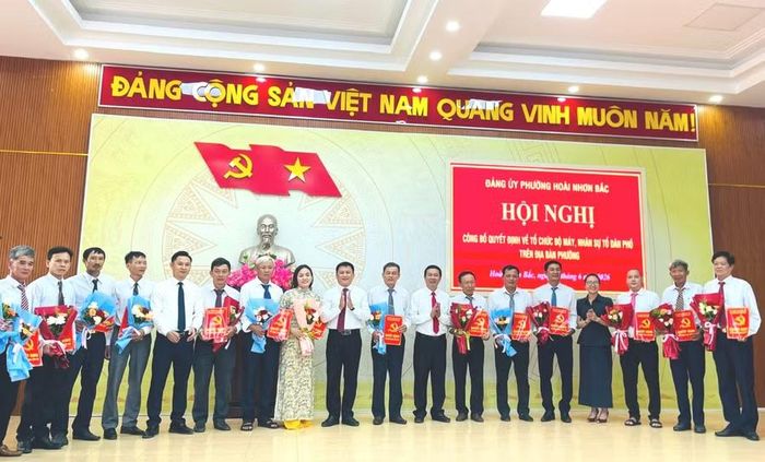  Đồng chí Vũ Thị Nga - Phó Giám đốc Báo và phát thanh, truyền hình Gia Lai (thứ 4 từ phải sang) cùng lãnh đạo phường Hoài Nhơn Bắc trao quyết định, tặng hoa cho các bí thư chi bộ tổ dân phố mới. Ảnh: Trung Nghĩa 