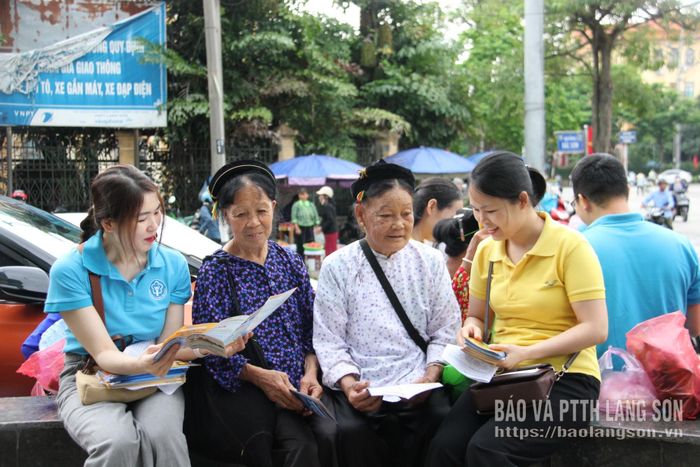 Nhân viên bảo hiểm xã hội tỉnh và Bưu điện Đông Kinh tuyên truyền, vận động người dân tham gia bảo hiểm y tế hộ gia đình