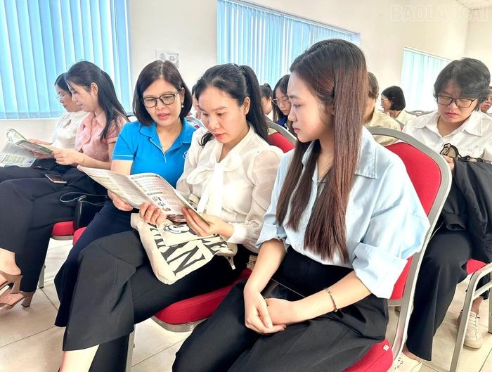 Viên chức Bảo hiểm xã hội tỉnh Lào Cai phát tờ gấp và trực tiếp giải đáp những thắc mắc của người lao động về chế độ, chính sách BHXH, BHYT.