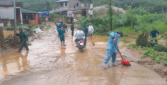  Lực lượng dân quân tham gia cùng người dân vệ sinh đường phố. 