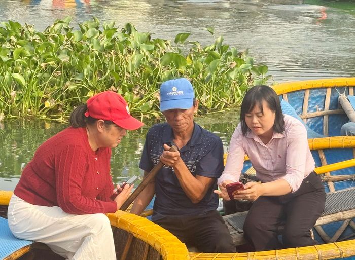 Cán bộ NHCSXH Hội An Đông hướng dẫn hộ vay sử dụng các dịch vụ của Ngân hàng qua app.