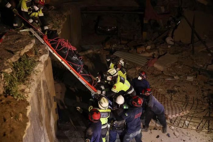 Đội cứu hộ EQ11 đưa thi thể một nạn nhân ra khỏi đống đổ nát. Ảnh: Reuters