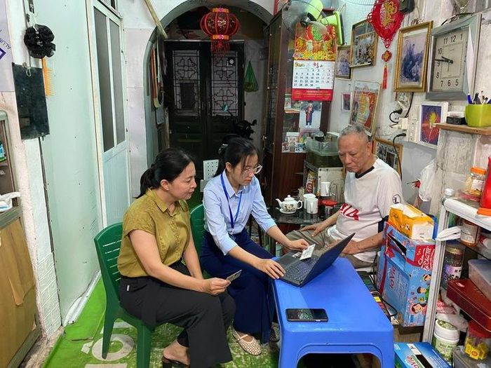 Cán bộ tiếp nhận hồ sơ và hướng dẫn người cao tuổi thực hiện kê khai trực tuyến.