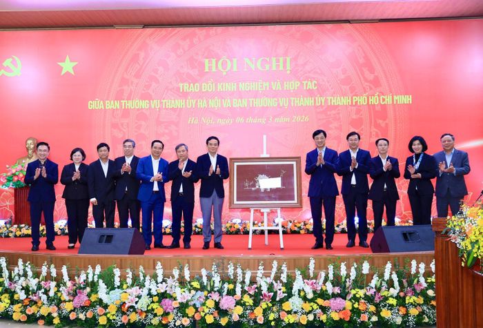 Các đồng chí lãnh đạo thành phố Hà Nội tặng quà các đồng chí lãnh đạo thành phố Hồ Chí Minh tại hội nghị trao đổi kinh nghiệm và hợp tác tháng 3-2026. Ảnh: Quang Thái