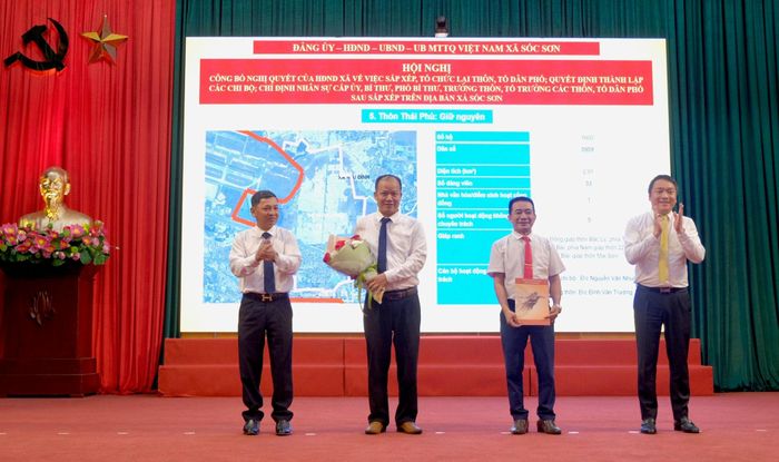 Thường trực Đảng ủy xã Sóc Sơn trao quyết định cho Bí thư Chi bộ và Trưởng thôn Thái Phù. Ảnh: Tùng Nguyễn